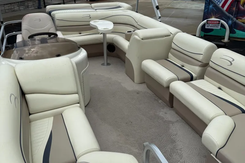 Slide: The Image of 2009 Bennington 1850GL boat interior with beige seating and a small table. - 5