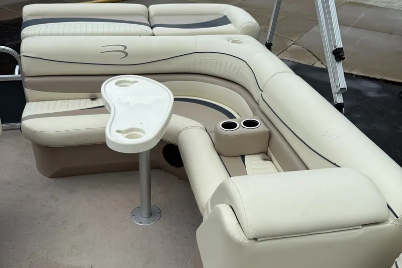Slide: The Image of 2009 Bennington 1850GL boat interior with beige seating and cup holders. - 8