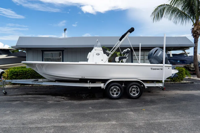 The Image of 2026 Tidewater 2110 Bay Max boat on trailer, parked near a building with palm trees. - 0