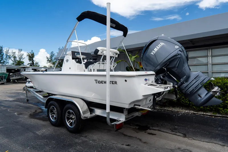 Slide: The Image of 2026 Tidewater 2110 Bay Max boat with Yamaha engine on trailer, parked outdoors. - 2