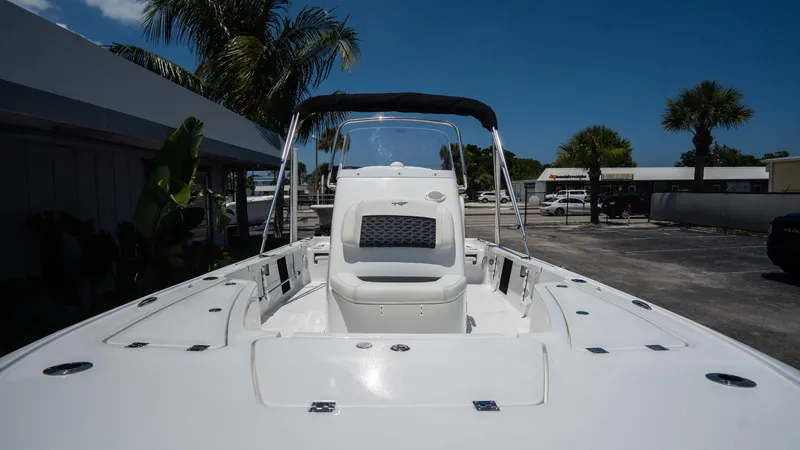 Slide: The Image of 2025 Tidewater 2110 Bay Max boat with T-top, docked under clear blue sky. - 5
