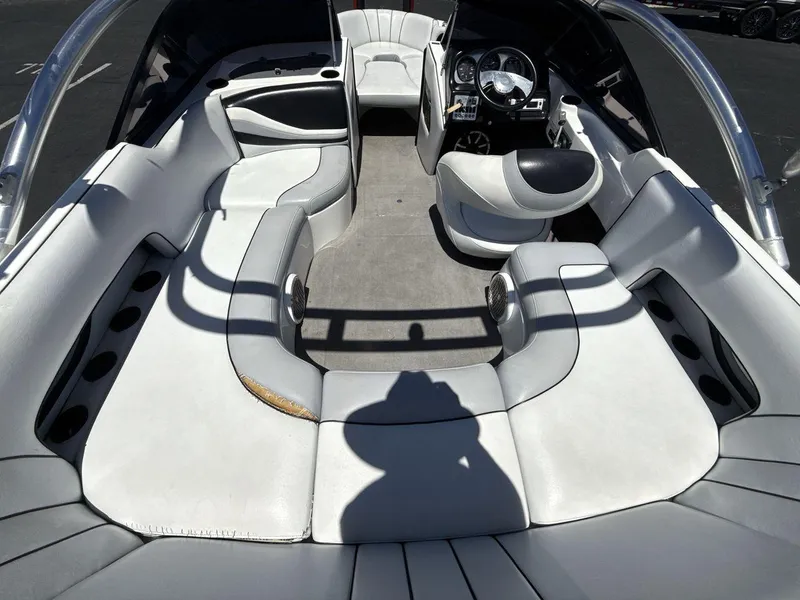 Slide: The Image of Interior of a 2006 MB Sport 220v boat with white seating and dashboard. - 10