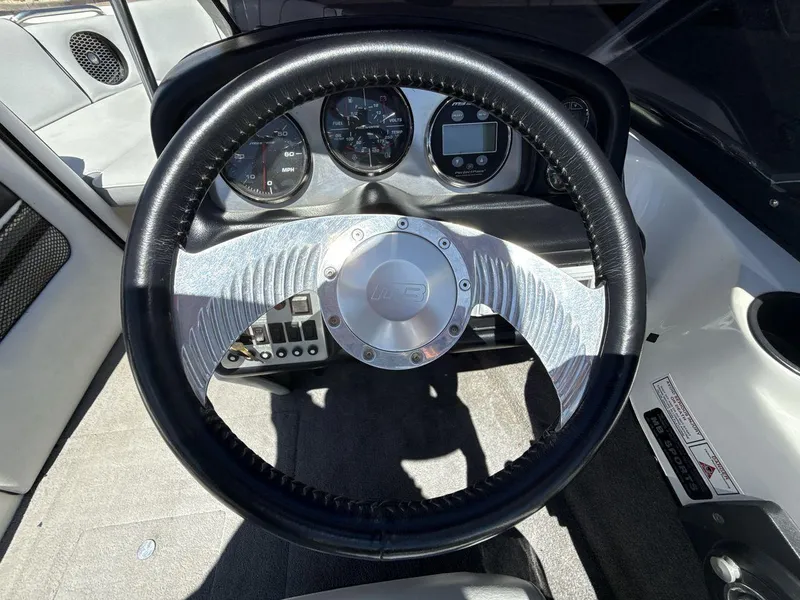 Slide: The Image of Steering wheel and dashboard of 2006 MB Sport 220v boat, featuring gauges and controls. - 14