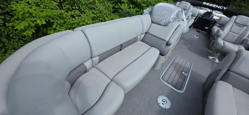 Slide: The Image of 2022 Regency 230 LE3 pontoon boat interior with plush gray seating and modern design. - 3