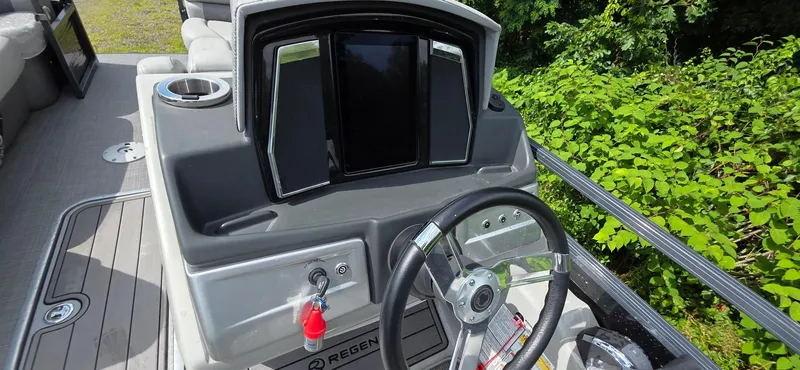 Slide: The Image of 2022 Regency 230 LE3 boat dashboard with steering wheel and control panel. - 5