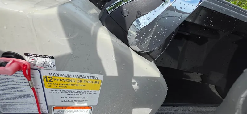 Slide: The Image of 2022 Regency 230 LE3 boat capacity label, showing maximum capacity of 12 persons or 1700 lbs. - 6