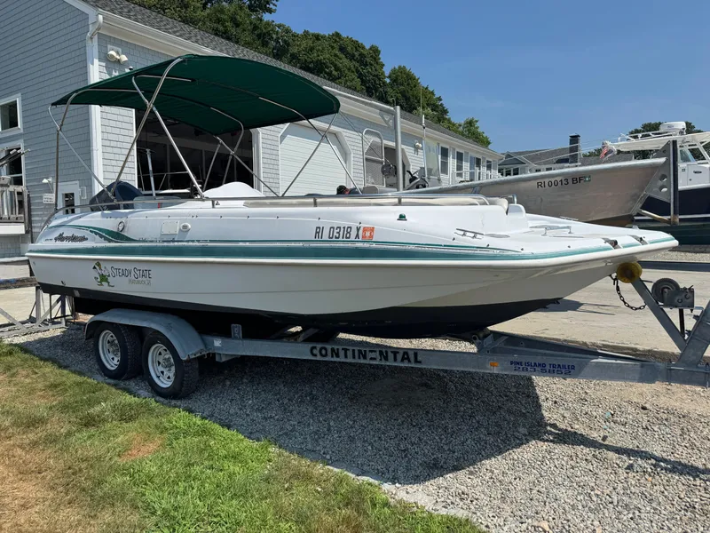 The Image of 2001 Hurricane FunDeck GS 201 OB boat on trailer, parked outdoors with green canopy. - 0