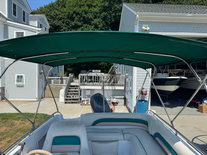 Slide: The Image of 2001 Hurricane FunDeck GS 201 OB boat with green canopy, docked near a house. - 14