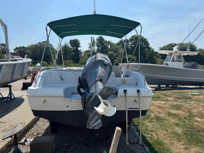 Slide: The Image of 2001 Hurricane FunDeck GS 201 OB boat with canopy and outboard motor, parked on gravel. - 4