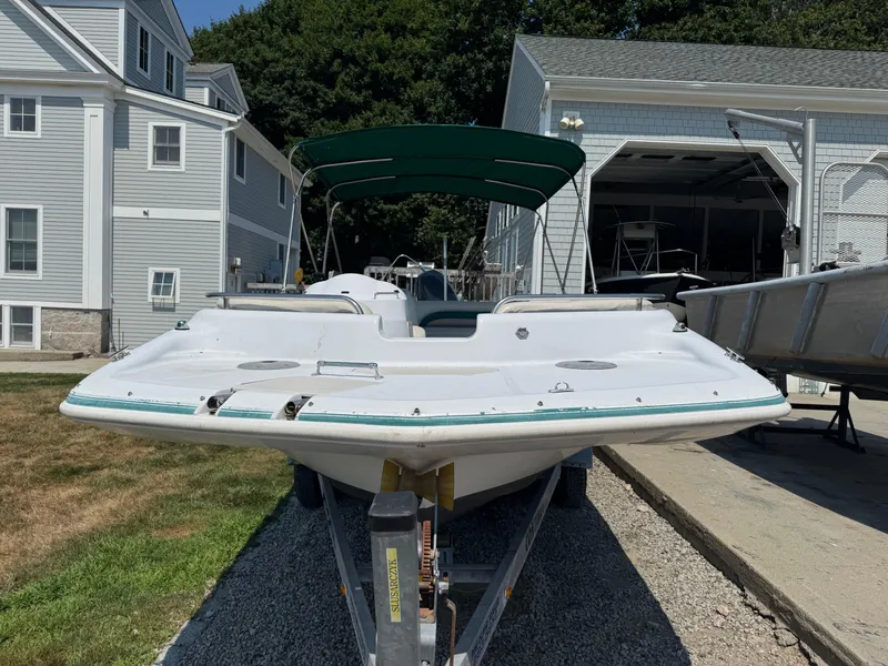 Slide: The Image of 2001 Hurricane FunDeck GS 201 OB boat on trailer, parked near residential buildings. - 6