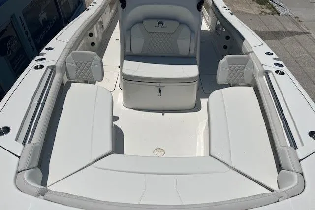 Slide: The Image of 2026 World Cat 325 CC boat interior with white cushioned seating and storage. - 3