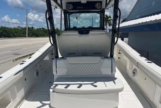 Slide: The Image of 2026 World Cat 325 CC boat interior with seating and console, under a sunny sky. - 7