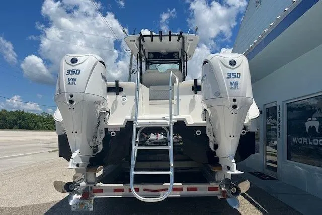 Slide: The Image of 2026 World Cat 325 CC boat with twin 350 V6 engines, parked outdoors. - 8