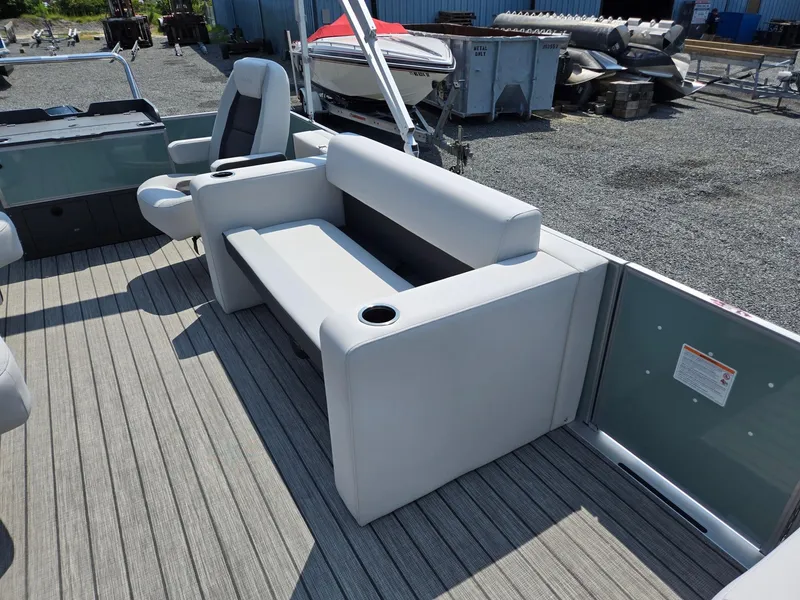 Slide: The Image of 2026 Harris Cruiser 210 boat interior with gray seating and cup holders on a wooden deck. - 13