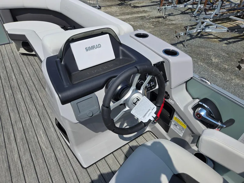 Slide: The Image of 2026 Harris Cruiser 210 boat dashboard with Simrad display and steering wheel. - 16