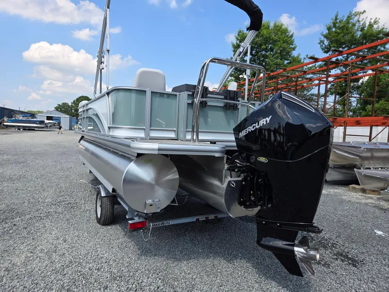 Slide: The Image of 2026 Harris Cruiser 210 pontoon boat with Mercury engine on gravel lot. - 3