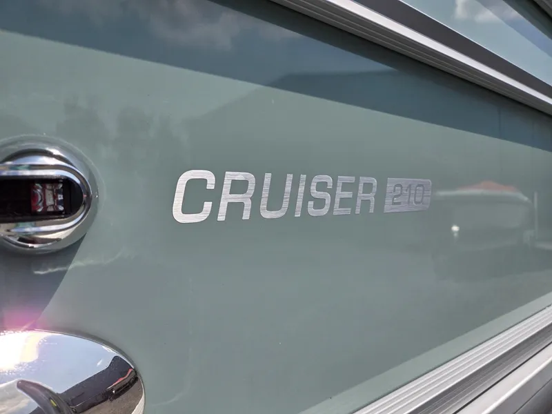 Slide: The Image of 2026 Harris Cruiser 210 boat emblem on a sleek metallic surface. - 40