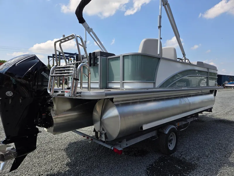 Slide: The Image of 2026 Harris Cruiser 210 pontoon boat on trailer, featuring a powerful outboard motor. - 5