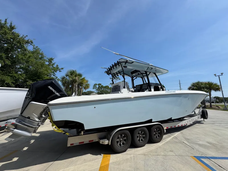 Slide: The Image of 2022 Fountain 38TE boat on trailer, parked outdoors under clear blue sky. - 10