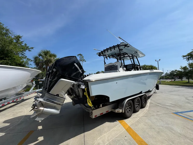 Slide: The Image of 2022 Fountain 38TE boat on trailer with Mercury outboard engines, parked outdoors. - 11