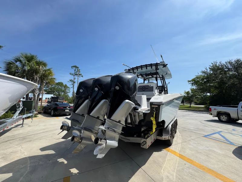 Slide: The Image of 2022 Fountain 38TE boat with triple outboard engines in a sunny parking lot. - 12