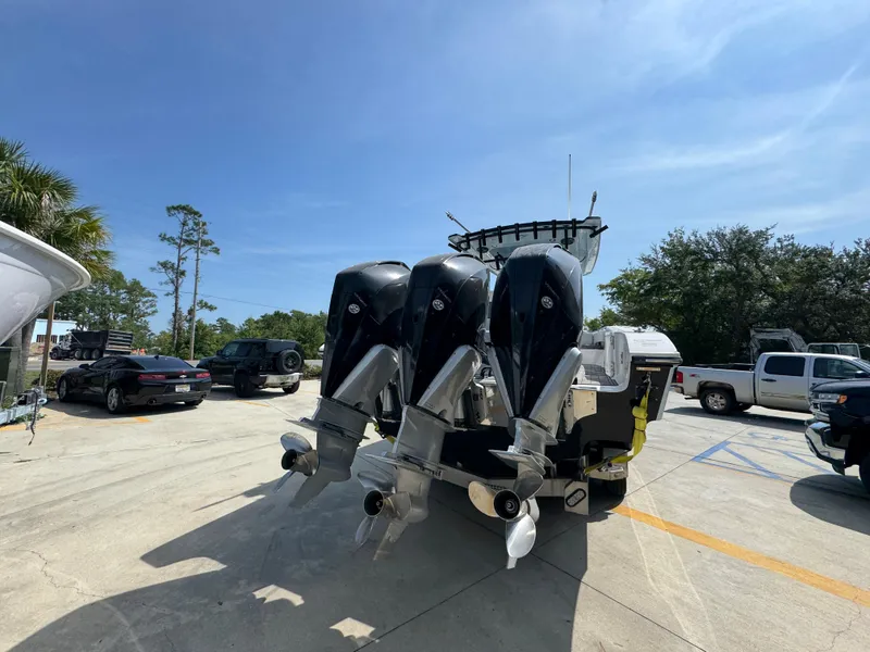 Slide: The Image of 2022 Fountain 38TE boat with triple outboard engines in a parking lot. - 13