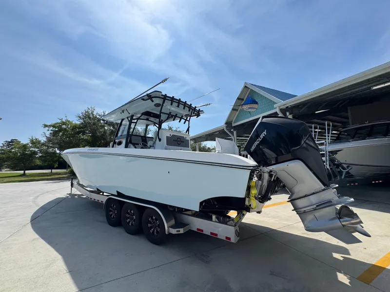 Slide: The Image of 2022 Fountain 38TE boat on trailer, parked outdoors under clear blue sky. - 16