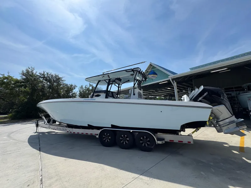 Slide: The Image of 2022 Fountain 38TE boat on trailer, parked outdoors under clear sky. - 17