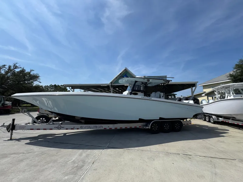 Slide: The Image of 2022 Fountain 38TE boat on trailer under clear blue sky. - 2