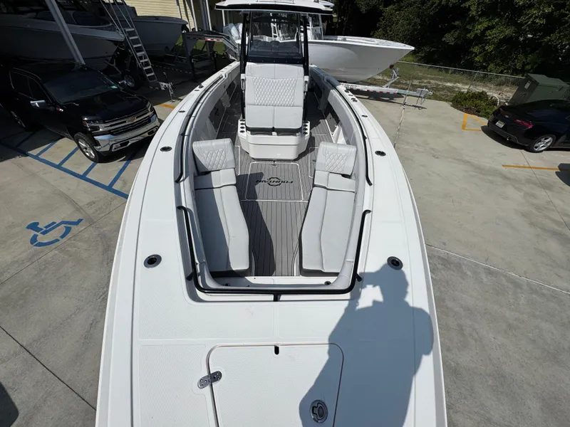 Slide: The Image of 2022 Fountain 38TE boat with spacious seating, docked near vehicles in a parking area. - 21