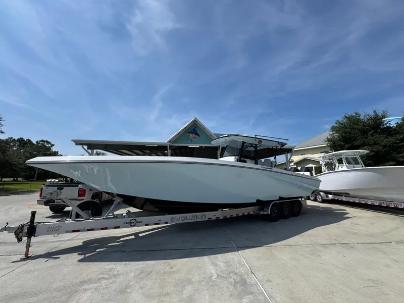Slide: The Image of 2022 Fountain 38TE boat on trailer, parked outdoors under clear blue sky. - 3