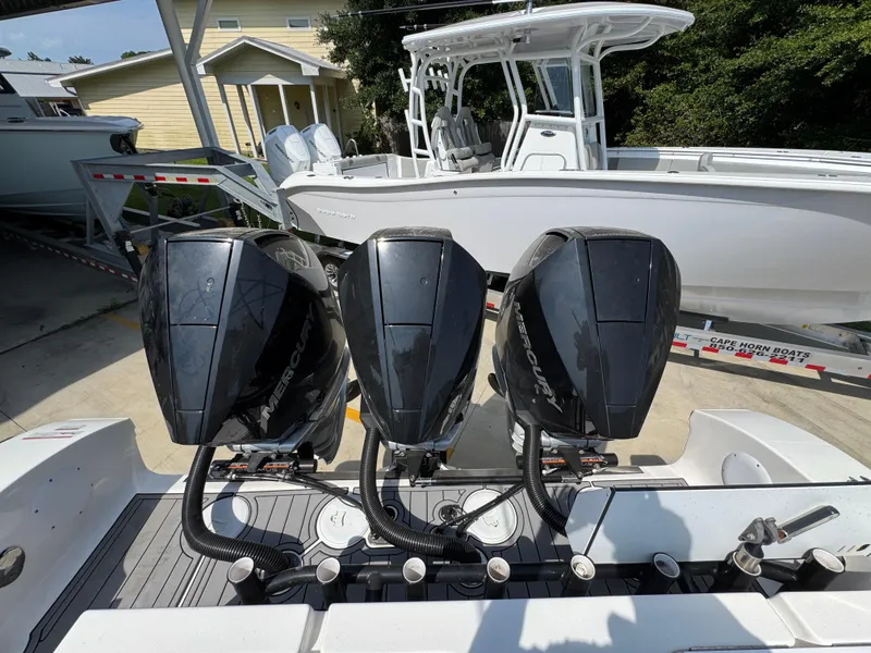 Slide: The Image of Triple Mercury outboard engines on a 2022 Fountain 38TE boat, parked on a trailer. - 41