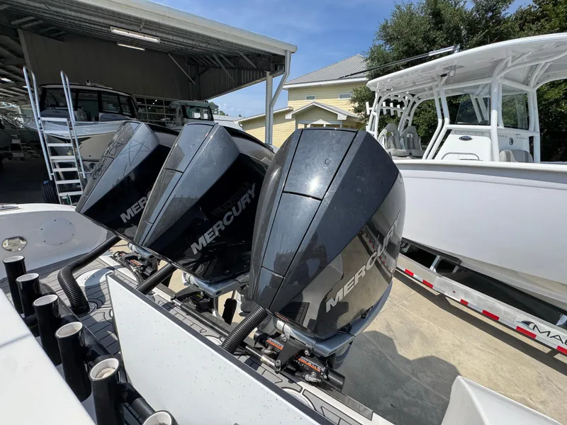 Slide: The Image of Triple Mercury outboard engines on a 2022 Fountain 38TE boat, docked outdoors. - 42