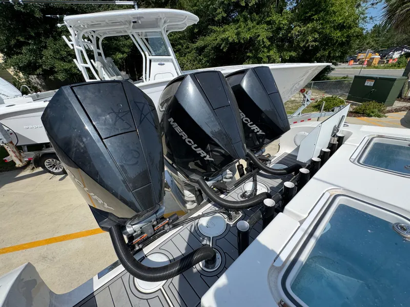 Slide: The Image of Triple Mercury outboard engines on a 2022 Fountain 38TE boat, docked outdoors. - 43