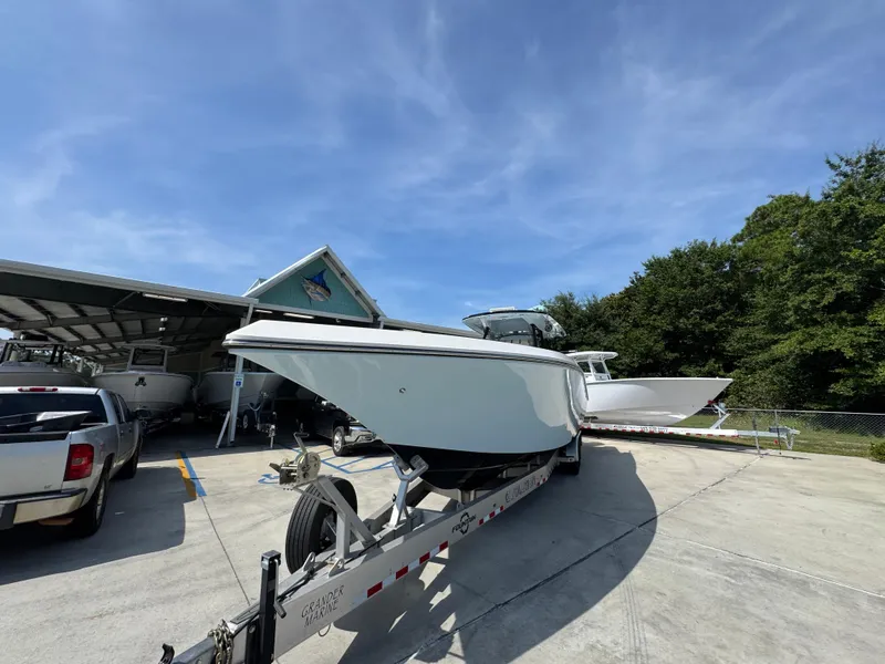Slide: The Image of 2022 Fountain 38TE boat on trailer at marina under clear blue sky. - 5