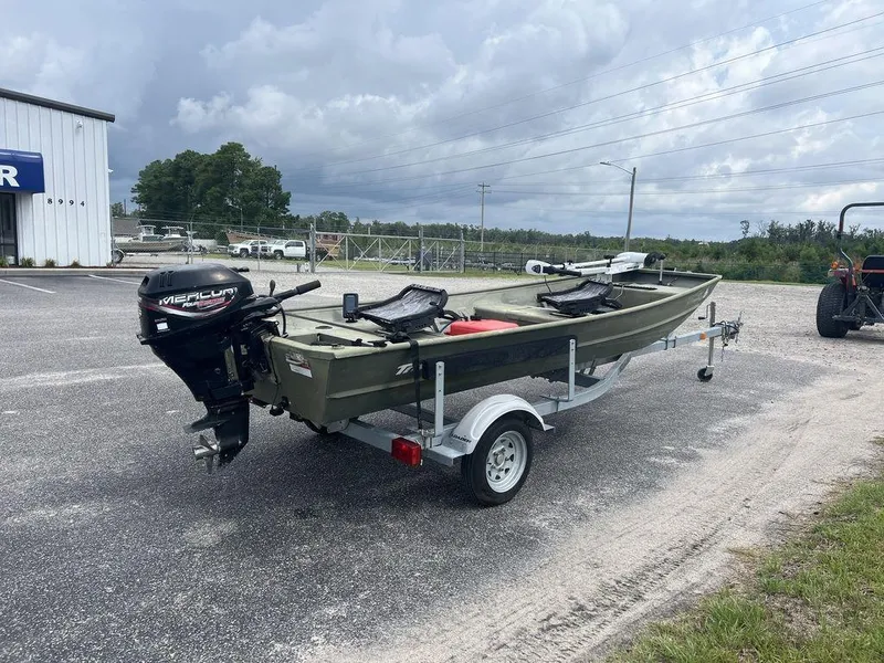 Slide: The Image of 2010 Triton 14' Jon boat on trailer with Mercury outboard motor, parked outdoors. - 11