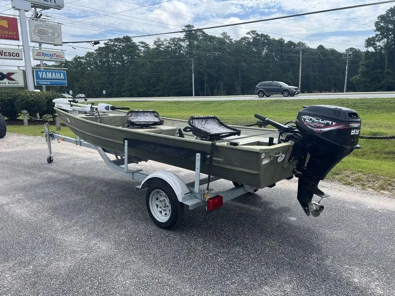 Slide: The Image of 2010 Triton 14' Jon boat on trailer with Mercury outboard motor, parked outdoors. - 4