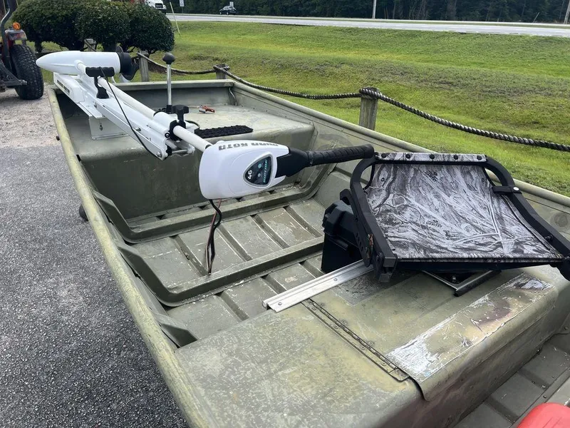 Slide: The Image of 2010 Triton 14' Jon boat with trolling motor and seat, parked on a roadside. - 8