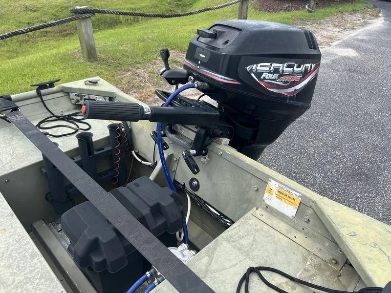 Slide: The Image of 2010 Triton 14' Jon boat with Mercury outboard motor, parked on a paved surface. - 9
