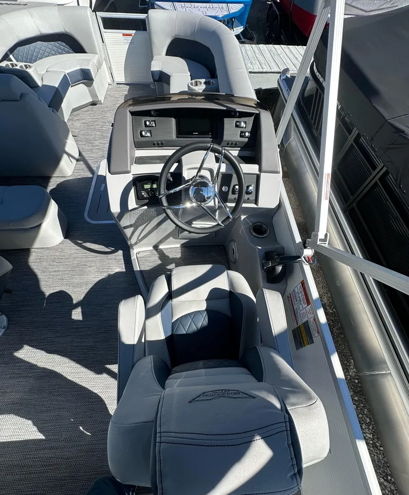 Slide: The Image of 2024 Bennington L 23 Swingback boat interior with steering wheel and seating. - 4