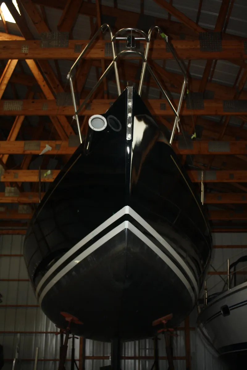 Slide: The Image of 2002 J Boats J/105 sailboat in storage, viewed from the bow, under wooden rafters. - 6