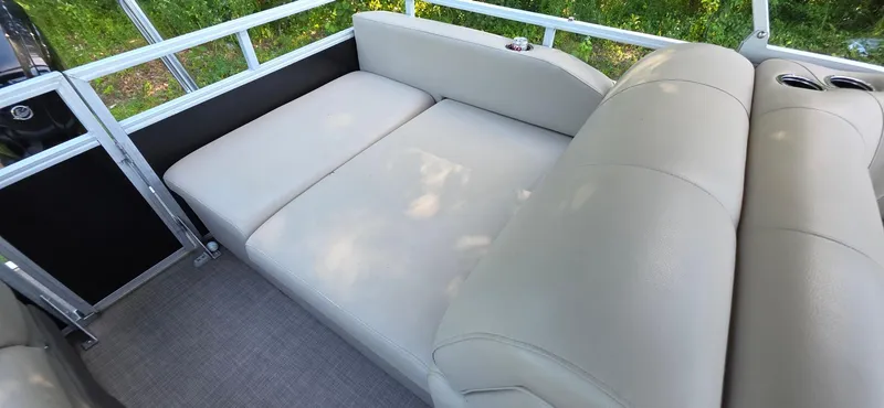 Slide: The Image of 2021 Sun Tracker 22 Party Barge RF interior with beige seating and cup holders. - 11