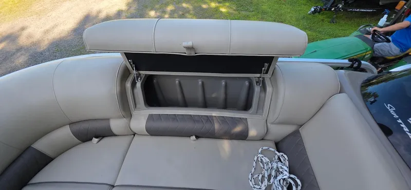 Slide: The Image of 2021 Sun Tracker 22 Party Barge RF interior with open storage compartment and seating. - 3
