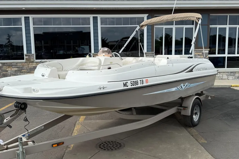 Slide: The Image of 2007 Smoker Craft Vectra 2040 boat on trailer, parked outside a building. - 1