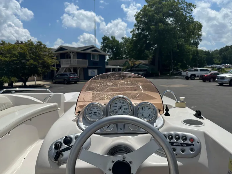 Slide: The Image of 2007 Smoker Craft Vectra 2040 boat dashboard with gauges and steering wheel, parked outdoors. - 10