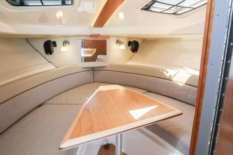 Slide: The Image of 2026 Cutwater C-248 Coupe interior with cozy seating and wooden table. - 10
