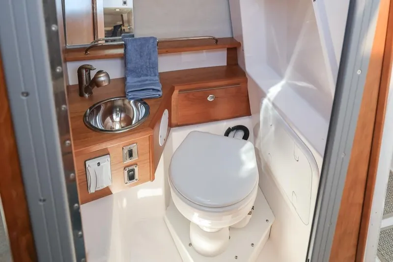 Slide: The Image of 2026 Cutwater C-248 Coupe bathroom with sink, toilet, and wooden cabinetry. - 12