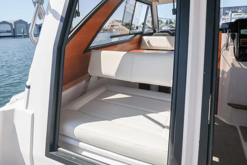 Slide: The Image of 2026 Cutwater C-248 Coupe interior with white seating, docked by the water. - 3