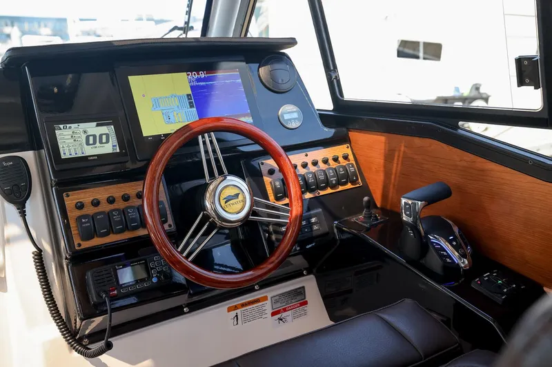 Slide: The Image of 2026 Cutwater C-248 Coupe helm with wood accents, modern controls, and navigation screens. - 7