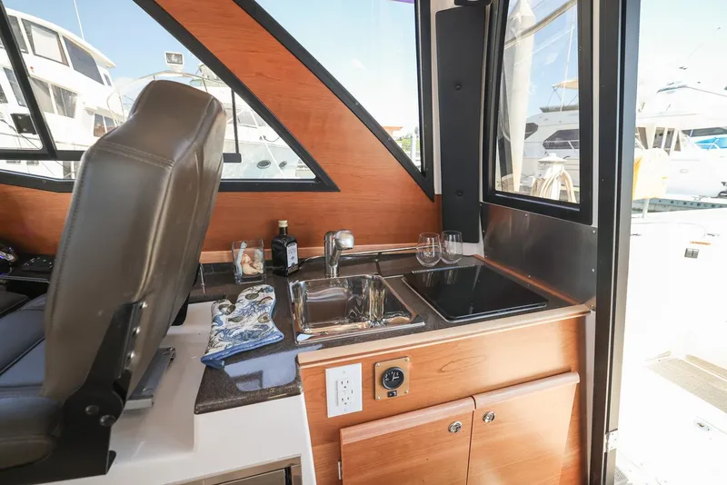 Slide: The Image of Interior of 2026 Cutwater C-248 Coupe featuring a compact kitchenette with sink and stove. - 8